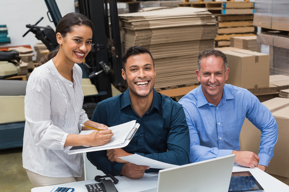 Smiling warehouse managers working together in a large warehouse