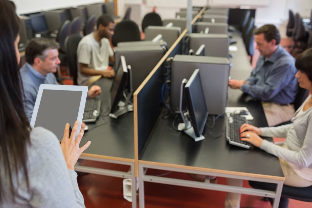 Woman holding a tablet pc while teaching her computer class