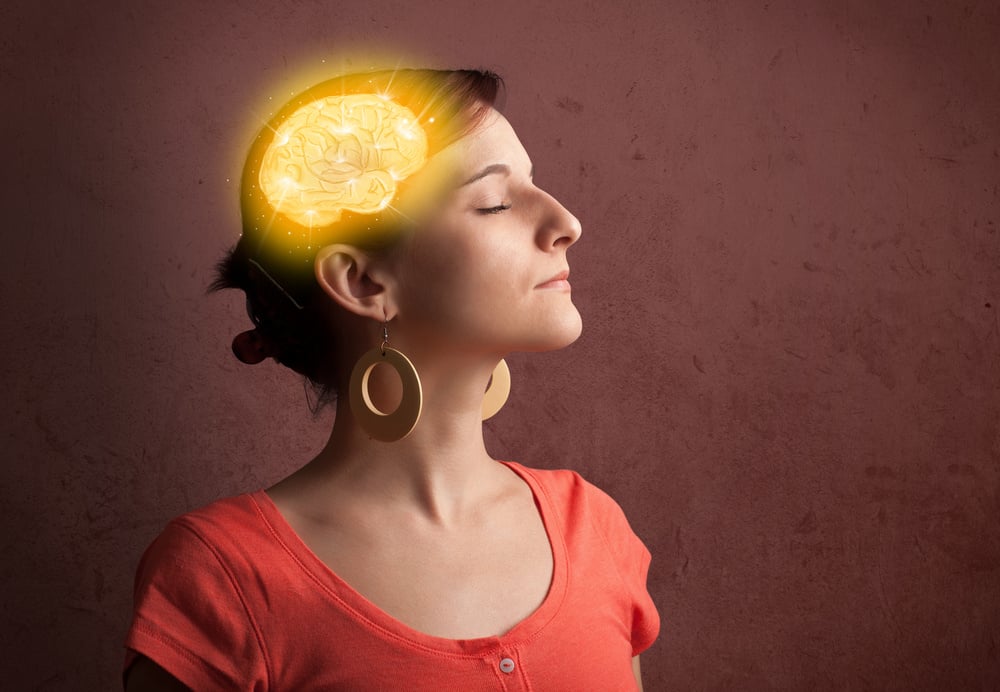 Young girl thinking with glowing brain illustration on grungy background