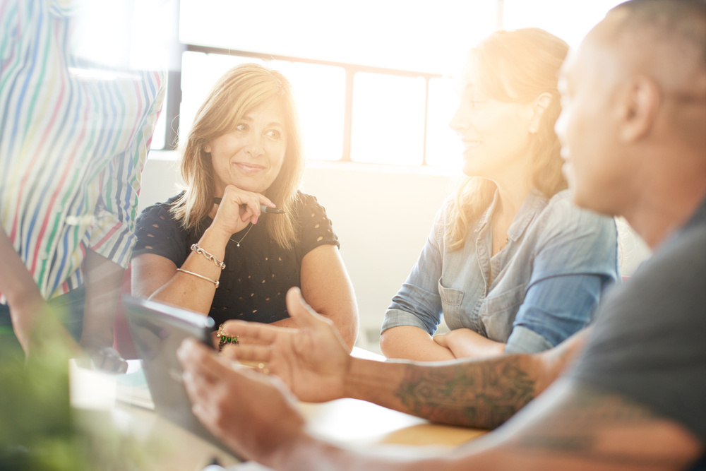 Unposed group of creative business people in an open concept office brainstorming their next project.-1